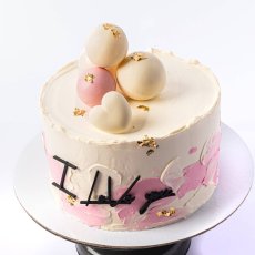 10. Dvojfarebná torta s čokoládovými guličkami a ozdobným nápisom