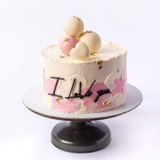 10. Dvojfarebná torta s čokoládovými guličkami a ozdobným nápisom