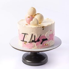 10. Dvojfarebná torta s čokoládovými guličkami a ozdobným nápisom