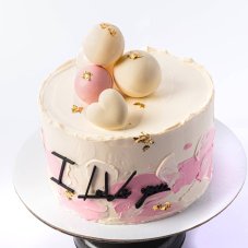 10. Dvojfarebná torta s čokoládovými guličkami a ozdobným nápisom
